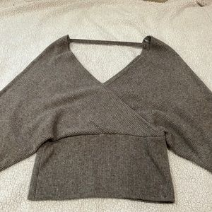 Dark grey ish long sleeve shirt with loose sleeves going fitted to wrist
